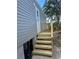 Exterior view showing gray siding and wooden steps leading to the entrance at 1925 Patriot Ln, Holiday, FL 34690