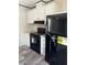 Modern kitchen with white cabinets, black appliances, and vinyl flooring at 1925 Patriot Ln, Holiday, FL 34690