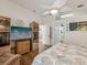 Main bedroom with large TV, comfy seating, and en-suite bathroom at 11654 Holly Ann Dr, New Port Richey, FL 34654