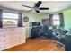 Cozy bedroom with ceiling fan, natural light, and hardwood floors at 12832 3Rd Isle, Hudson, FL 34667