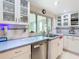 Bright kitchen with stainless steel appliances, white cabinetry, and a scenic window view at 12832 3Rd Isle, Hudson, FL 34667