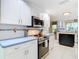 Modern kitchen with stainless steel appliances, ample counter space, and stylish tile backsplash at 12832 3Rd Isle, Hudson, FL 34667