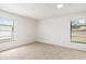 Bright bedroom with two windows and neutral carpeting at 2027 Beckwith Ave, Spring Hill, FL 34608