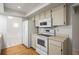 White kitchen cabinets, appliances, and wood floor at 2027 Beckwith Ave, Spring Hill, FL 34608