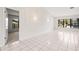 Open living room with tile floors and view into bedroom at 2027 Beckwith Ave, Spring Hill, FL 34608