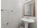 Small bathroom with pedestal sink, mirror, and single light fixture at 37351 Neighbors Path, Zephyrhills, FL 33542