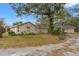 Tan house with a garage and mature trees in the yard at 37351 Neighbors Path, Zephyrhills, FL 33542