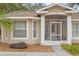 House entrance with screened porch and landscaping at 37351 Neighbors Path, Zephyrhills, FL 33542