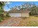 White double-door garage with gravel driveway at 37351 Neighbors Path, Zephyrhills, FL 33542