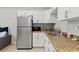 Modern kitchen with white cabinets, granite countertops, and stainless steel appliances at 37351 Neighbors Path, Zephyrhills, FL 33542