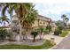 Tan three-story house with palm trees and a long driveway at 5406 Captains Ct, New Port Richey, FL 34652