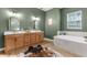 Bright bathroom featuring a large vanity with double sinks and a soaking tub with tile surround at 7376 Fall St, Brooksville, FL 34613