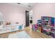 bedroom with pink walls, a single bed, toys, and direct access to the bathroom and laundry room at 7376 Fall St, Brooksville, FL 34613