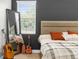 Stylish bedroom with a modern bed, accent wall, window, and full-length mirror for a comfortable retreat at 7376 Fall St, Brooksville, FL 34613