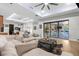 Bright living room with a large sectional sofa, modern lighting, and sliding glass doors to the backyard at 7376 Fall St, Brooksville, FL 34613