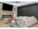 Living room featuring a stone fireplace, a large screen TV, and a comfortable white sectional sofa at 7376 Fall St, Brooksville, FL 34613