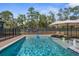 Sparkling in-ground pool with lounge chairs and a secure safety fence at 7376 Fall St, Brooksville, FL 34613