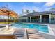 Backyard pool with in-pool seating, an umbrella, and a covered patio with views of the house at 7376 Fall St, Brooksville, FL 34613