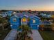 Two-story waterfront home with double garage, palm trees, and sunset view at 7516 Gulf Way, Hudson, FL 34667