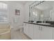 Double vanity bathroom with granite countertops and a large mirror at 591 Waterford W Cir, Tarpon Springs, FL 34688
