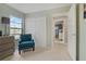 Bright bedroom with a teal armchair and double doors to a closet at 591 Waterford W Cir, Tarpon Springs, FL 34688