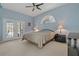 Bright bedroom with a king-size bed, double doors leading to a patio, and ample natural light at 591 Waterford W Cir, Tarpon Springs, FL 34688