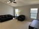 Relaxing living room with leather furniture and two windows at 591 Waterford W Cir, Tarpon Springs, FL 34688