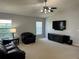Spacious living room featuring a large TV, comfortable seating, and neutral color palette at 591 Waterford W Cir, Tarpon Springs, FL 34688