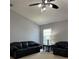 Bright living room featuring a ceiling fan and leather sofas at 591 Waterford W Cir, Tarpon Springs, FL 34688
