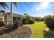 Landscaped backyard with lush lawn and tropical plants at 13235 Legends Trl, Dade City, FL 33525