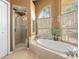 Bathroom with a walk-in shower and a soaking tub at 13235 Legends Trl, Dade City, FL 33525