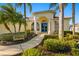 Front entrance of the home with a walkway, lush landscaping and blue door at 13235 Legends Trl, Dade City, FL 33525