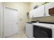 Laundry room with washer, dryer, and overhead cabinets at 13235 Legends Trl, Dade City, FL 33525