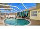 Relaxing kidney-shaped pool with screened enclosure and patio furniture at 13235 Legends Trl, Dade City, FL 33525