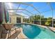 Screened-in kidney shaped pool with lounge chair and lush landscaping at 13235 Legends Trl, Dade City, FL 33525