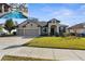 House exterior featuring a three-car garage and well-manicured lawn at 692 Challice Dr, Spring Hill, FL 34609