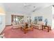 Living room featuring light pink carpeting, floral sofas, and a coffee table at 9172 Horizon Dr, Spring Hill, FL 34608