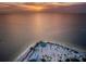Aerial view of a sandy beach, gazebo, and parking area at sunset at 1545 Citrine Trl, Tarpon Springs, FL 34689