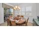 Bright dining room with round wooden table and six chairs, featuring plantation shutters at 1545 Citrine Trl, Tarpon Springs, FL 34689