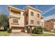 Three-story home with beige exterior, two balconies, and a two-car garage at 1545 Citrine Trl, Tarpon Springs, FL 34689