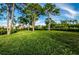 Green grassy lawn with mature trees and a gazebo at 1545 Citrine Trl, Tarpon Springs, FL 34689