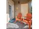 Inviting patio with two orange chairs and a sun-themed decoration at 1545 Citrine Trl, Tarpon Springs, FL 34689