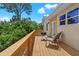 Deck with wooden railing, chairs, and grill, overlooking backyard at 15806 Adobe Dr, Hudson, FL 34667