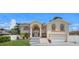 Tan two-story house with a two-car garage and landscaped yard at 15806 Adobe Dr, Hudson, FL 34667