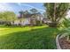 Landscaped backyard with lush grass and mature trees at 2476 Silkwood Ct, Spring Hill, FL 34606