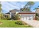 Beautiful two-story home with a red accent and lush landscaping at 2476 Silkwood Ct, Spring Hill, FL 34606