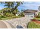 Large front yard with paver driveway and tropical landscaping at 2476 Silkwood Ct, Spring Hill, FL 34606