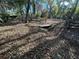 Large backyard with leaf-covered ground and bridge at 3234 Ella Ln, New Port Richey, FL 34655
