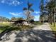 House with long driveway, palm trees, and a fenced backyard at 3234 Ella Ln, New Port Richey, FL 34655