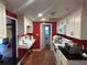 Galley kitchen with white cabinets, red walls, and a white sink at 3234 Ella Ln, New Port Richey, FL 34655